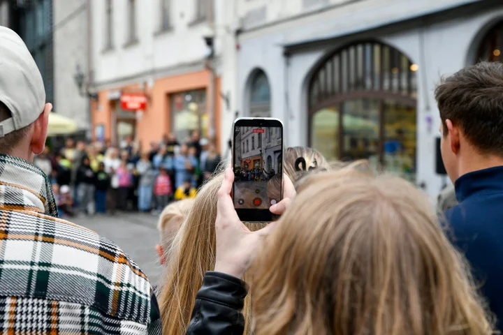 Obiskovalec s pametnim telefonom posname dogajanje na ulici starega mestnega jedra