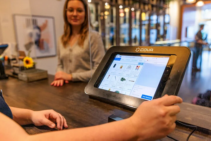 A guest pays at a counter using a tablet till