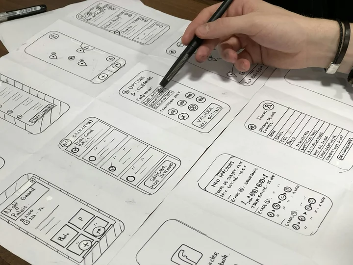 Hand-drawn wireframes of mobile app screens